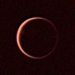 NASA's Voyager 2 obtained this wide-angle image of the night side of Titan on Aug. 25, 1979. This is a view of Titan's extended atmosphere. the bright orangish ring being caused by the atmosphere's scattering of the incident sunlight.