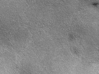 This image captured during March 1999 by NASA's Mars Global Surveyor shows summertime in the northern hemisphere of Mars with the northern plains clearly in view. The image is located near Lomonosov Crater on the Vastitas Borealis plain.