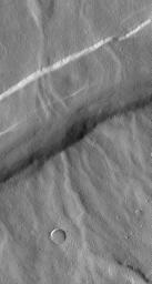 NASA's Mars Global Surveyor shows valleys on the northwest flank of Alba Patera Volcano which are old and have been cut by younger faults that created graben.