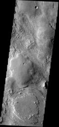 The wind is eroding some of the materials in this region more readily than others, indicating a complex surface history on Mars. This image was taken by NASA's Mars 2001 Odyssey spacecraft.
