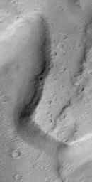NASA's Mars Global Surveyor shows escarpments and valleys on the lower northeast flank of Tyrrhenna Patera, thought to be an ancient volcano located in Hesperia Planum in the martian southern hemisphere.