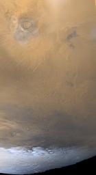 NASA's Mars Global Surveyor shows a frosty, retreating south polar cap (white) on Mars, and wisps of dust storm clouds (grayish-orange). Also seen is the southern most of the large environmental changes volcanoes, Arsia Mons.