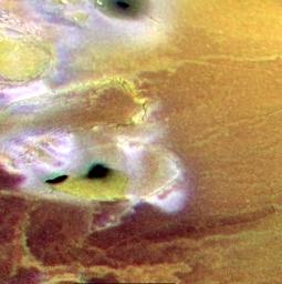 Volcanic calderas, lava flows and cliffs are seen in this false color image of a region near the south pole of Jupiter's volcanic moon Io, created by combining a black and white image taken by NASA's Galileo spacecraft with lower resolution color images.