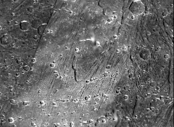 The shallow, scalloped depression in the center of this picture from NASA's Galileo spacecraft is a caldera-like feature 5 to 20 kilometers (3 to 12 miles) wide on Jupiter's largest moon, Ganymede.