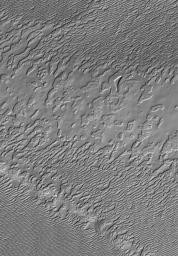 NASA's Mars Global Surveyor shows a view of frozen carbon dioxide in the south polar residual cap of Mars. Much of the south polar residual cap exhibits terrain that resembles stacks of sliced Swiss cheese.