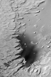 NASA's Mars Global Surveyor shows layered rock outcrops reaching deep down into the martian crust in the walls of the Valles Marineris. 