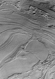 NASA's Mars Global Surveyor shows a jumble of plates or layers exposed at the surface but subsequently covered by a thin mantle to give northwestern Hellas Planitia on Mars a uniform brightness.