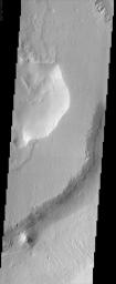 This image from NASA's Mars Odyssey shows a sample of the middle member of the Medusae Fossae formation. The layers exposed in the southeast-facing scarp suggest that there is a fairly competent unit underlying the mesa in the center of the image.