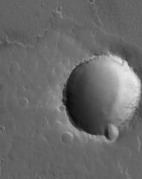 NASA's Mars Global Surveyor shows an impact crater in the volcanic Tharsis region of Mars. The margins of a lava flow are seen above the crater.