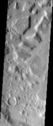 This NASA Mars Odyssey image shows the dissected interior of a crater in the Cydonia region of Mars. The flat-topped buttes and mesas in the northern portion of the image were once a continuous layer of material that filled the crater.
