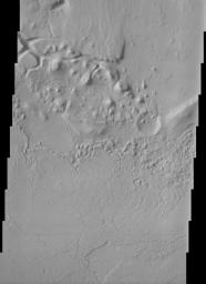 This NASA Mars Odyssey image shows parts of the dissected and eroded remnants of an impact crater rim and volcanic material located north of Apollinaris Patera near the southern highlands - northern lowlands dichotomy on Mars.