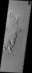 This image from NASA's Mars Odyssey shows ejecta surrounding a crater on Mars has undergone significant erosion by the wind. The wind has stripped the surface features from the ejecta and has started to winnow away the ejecta blanket. 