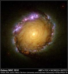 A rainbow of colors is captured in the center of a magnificent barred spiral galaxy, as witnessed by the three cameras of NASA's Hubble Space Telescope.