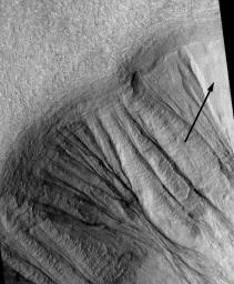 NASA's Mars Global Surveyor shows gullies on martian crater walls that may be carved by liquid water melting from remnant snow packs.