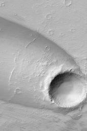 NASA's Mars Global Surveyor shows a complex streak formed by deposition and erosion of sediment by wind in the lee of an impact crater in western Daedalia Planum on Mars.