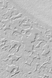 NASA's Mars Global Surveyor shows the 'swiss cheese' pattern of frozen carbon dioxide on the south polar residual cap. 