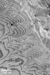 NASA's Mars Global Surveyor shows layered sedimentary rock outcrops in Becquerel Crater of western Arabia Terra on Mars. These materials were deposited in the crater some time in the distant past, and later eroded to their present form.