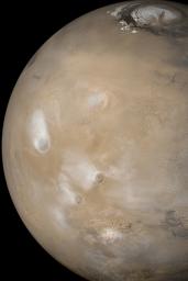 NASA's Mars Global Surveyor shows a dust storm raging in Syria Planum, south of the Labyrinthus Noctis troughs on Mars. Water ice clouds are present over each of the five largest Tharsis volcanoes.