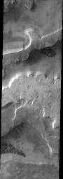 This image taken by NASA's 2001 Mars Odyssey shows 'etched terrain' near the south pole of Mars. In several places in this image there are large areas with many dark spots.