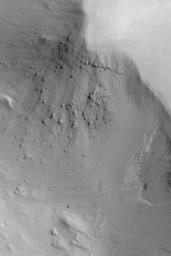 NASA's Mars Global Surveyor shows a boulder has rolled down a slope in the martian region of Gordii Dorsum of Mars. The boulder sits at the end of the track.