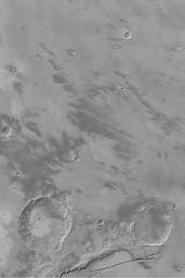 NASA's Mars Global Surveyor shows streaks in the lee of obstacles such as meteor impact craters and lava flow margins in southwestern Daedalia Planum on Mars.
