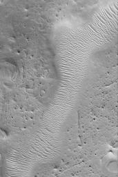 NASA's Mars Global Surveyor shows a portion of southern Auqakuh Vallis in northeastern Arabia Terra on Mars. The terrain surrounding the valley has been eroded such that only remnants of former craters and layered bedrock remain.