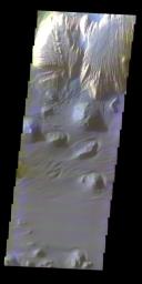 A layered deposit in Ganges Chasma provides a striking color contrast against dark dunes and sand sheets in this image taken in October 2003 by NASA's Mars Odyssey spacecraft.