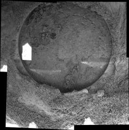 This image taken by the microscopic imager on NASA's Mars Exploration Rover Opportunity shows the hole drilled by the rover's rock abrasion tool into the rock dubbed 'Pilbara.' The process left a pile of rock powder around the side of the hole.