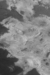NASA's Mars Global Surveyor shows exposures of finely-bedded sedimentary rocks in western Melas Chasma, part of the vast Valles Marineris trough system on Mars.