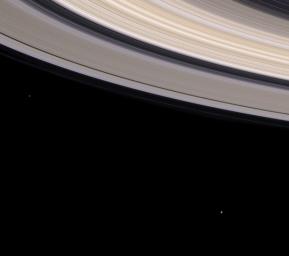 This image from NASA's Cassini spacecraft shows Saturn's colorful rings sweep through this spectacular natural color view while two small moons look on.