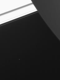 Saturn's moon Telesto is visible below and to the left of center in this image from NASA's Cassini spacecraft.