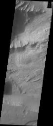 This image released on Sept 27, 2004 from NASA's 2001 Mars Odyssey shows a part of Candor Chasma on Mars. Wind etched surfaces are dominant on this picture, but gullies and layered rock formations are also present in this area.
