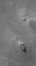 NASA's Mars Global Surveyor shows terrain in northwestern Argyre Planitia on Mars during southern autumn in August 2004. Several mesas stand high above a rippled plain.