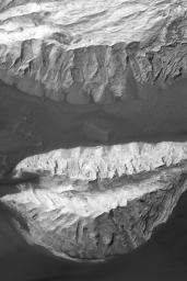 NASA's Mars Global Surveyor shows portions of two massifs composed of light-toned, sedimentary rock in Ganges Chasma, part of the Valles Marineris trough system on Mars.