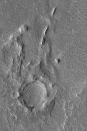 NASA's Mars Global Surveyor shows layered outcrops of sediment deposited in southern Chryse Planitia by flow through the Hypanis Valles system in Xanthe Terra on Mars. The distinct inverted boat hull-shaped ridges are yardangs formed by wind erosion.