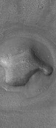 NASA's Mars Global Surveyor shows an eroded, rounded hill in the Deuteronilus Colles region of Mars. The plains surrounding the hill have been pitted and modified by erosion.