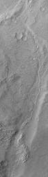 NASA's Mars Global Surveyor shows an inverted channel running down, through a valley in the Memnonia Sulci region of Mars. The original channel is gone, as are the rocks through which it cut.