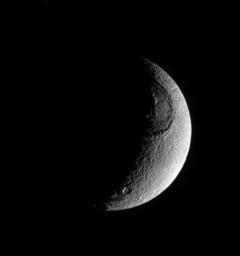 This richly textured look at Saturn's moon Tethys from NASA's Cassini spacecraft shows the huge crater Odysseus and its central mountain in relief, as well as many smaller impact sites.