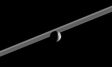 Impact-battered Mimas steps in front of Saturn's rings, showing off its giant 130-kilometer (80-mile) wide crater Herschel. This image was taken in visible green light with NASA's Cassini narrow-angle camera on Oct. 13, 2005.