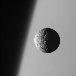 This amazing perspective view captures battered Mimas against the hazy limb of Saturn. Mimas has been badly scarred by impacts over the eons; its wide crater, Herschel, lies in the darkness at right as seen by NASA's Cassini spacecraft.