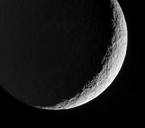 Rhea's devastated surface creates a jagged terminator as mountains and crater rims break-up the line between day and night. This image was taken in visible green light with NASA's Cassini spacecraft's narrow-angle camera on May 22, 2006.