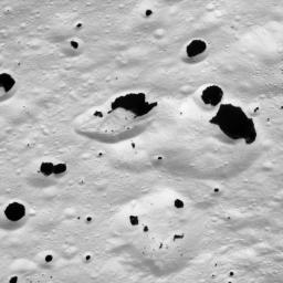 Dark material splatters the walls and floors of craters in the surreal, frozen wastelands of Iapetus as seen by NASA's Cassini spacecraft on Sept. 10, 2007.