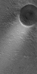 This NASA Mars Global Surveyor shows a wind streak created in the lee (downwind side) of a crater in far eastern Chryse Planitia. The winds responsible for the formation of the streak blew from the northeast to the southwest.
