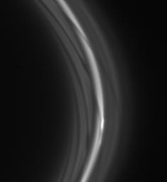 The striated appearance of the F ring is immediately apparent in the region of the ring that trails behind the moon Prometheus as seen by NASA's Cassini spacecraft.