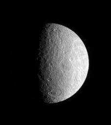 Large and medium-sized impact basins on Rhea's trailing hemisphere are thrown into sharp relief by the grazing rays of the Sun. This image was taken in visible light with NASA's Cassini spacecraft's narrow-angle camera.