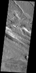 Located between Lycus Sulci and Acheron Fossae, the surface in this region has been modified by the wind. The bottom half of the image contains linear sand dunes on Mars as seen by NASA's Mars Odyssey spacecraft.