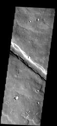 This image from NASA's Mars Odyssey spacecraft shows small bright dunes occurring along the margins of the graben that crosses this image. The graben is an extension of Noctis Labyrinthus into Sinai Planum.