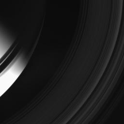 A sliver of 'ringshine' pierces the darkness of Saturn's night side in this image taken by NASA's Cassini spacecraft on Apr. 19, 2008. The ring shadows fall into darkness beyond the terminator in the north.