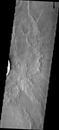This image from NASA's Mars Odyssey shows a crater just out of frame to the left in this image located on the floor of Schiaparelli Crater. Within the lows of the ejecta blanket of the small crater are old, linear dunes. 