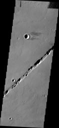 This image from NASA's Mars Odyssey shows a chain of collapse pits occurring within one of the many tectonic graben of the Tharsis region.
